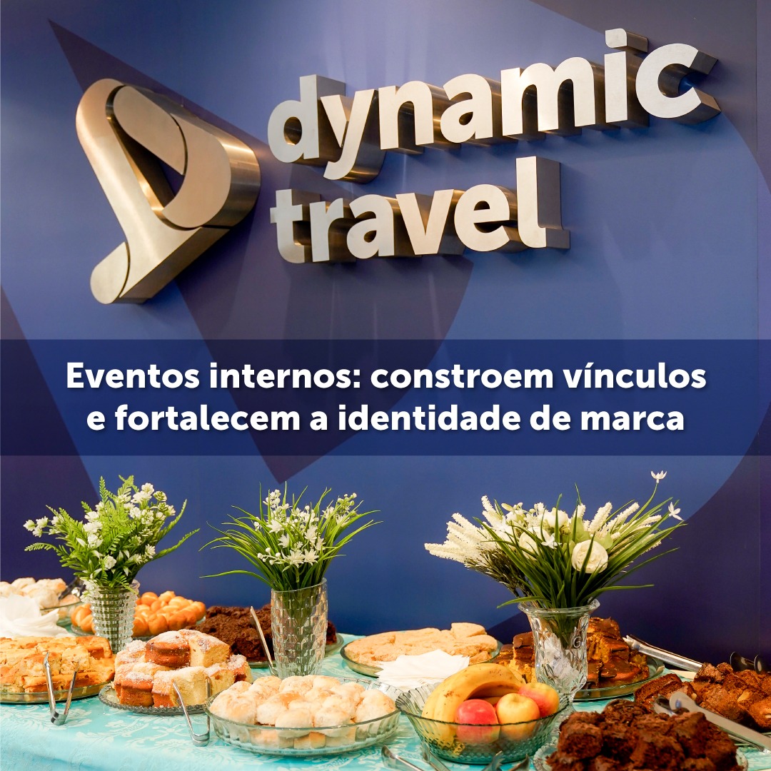 em uma mesa há vários pratos de comida, com uma decoração com flores, e de fundo o logo da Dynamic Travel