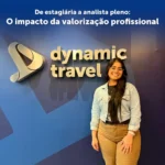 Raquel sorrindo e ao fundo temos o fundo da Dynamic Travel (azul)