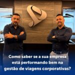 dois executivos de relacionamento em frente ao logo