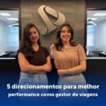 duas mulheres cruzando braços em frente ao logo da empresa